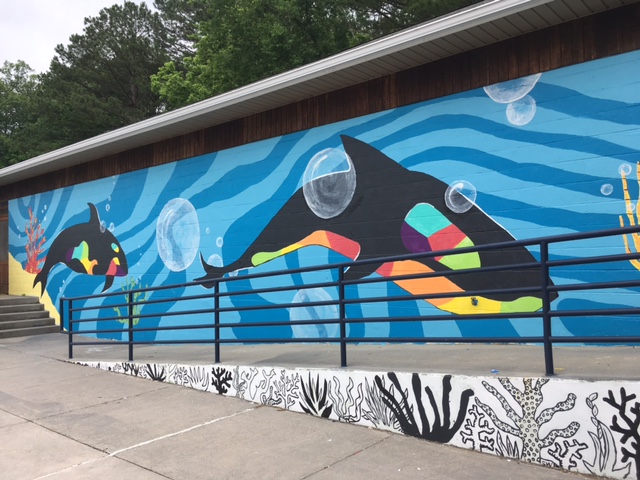 Families walking past the iconic underwater mural on the Oak Ridge pool building